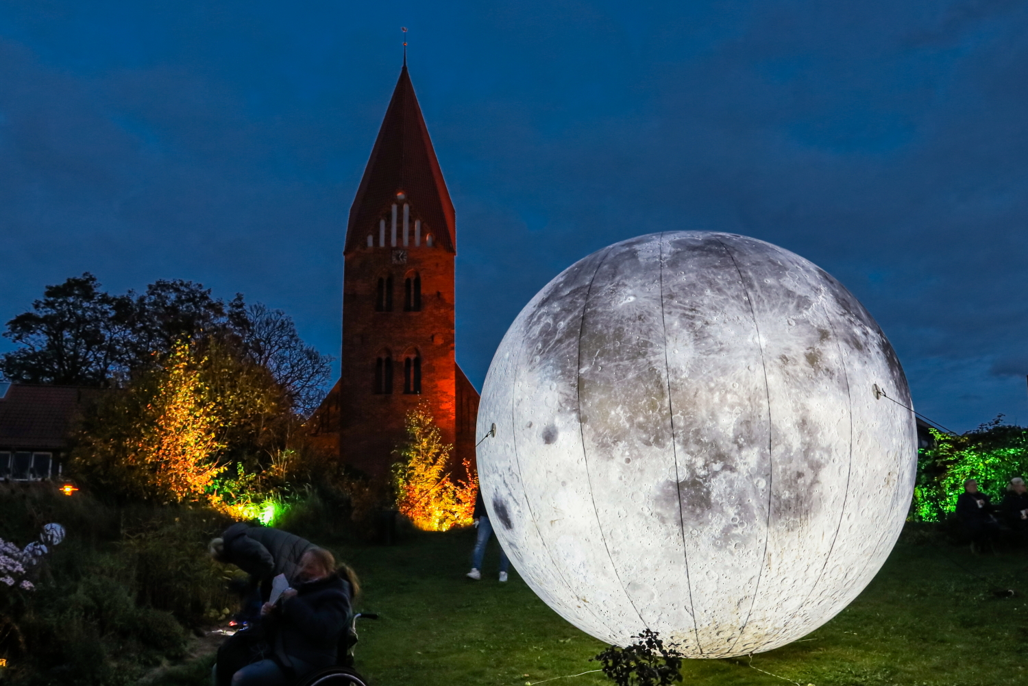 Leuchtender Mond im Stadtgarten Klütz - im Hintergrund die angestrahlte St. Marienkirche  © Helmut Strauß