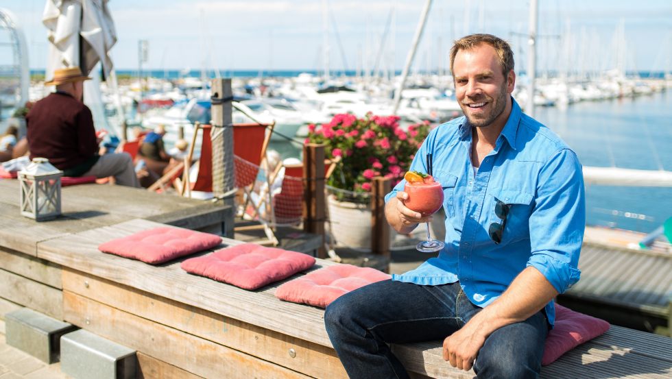 SOKO Wismar Kriminaloberkommissar Lars Pöhlmann, alias Dominic Boeer, genießt gern einen Cocktail im Bootshafen. © VMO, Alexander Rudolph